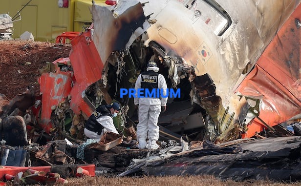 Police forensic investigators search through debris from the Jeju Air passenger plane crash and explosion at Muan International Airport in South Jeolla Province, on Dec. 30, 2024, a day after the accident./News1